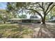 Rear exterior view of the single-story home with a screened-in back porch at 1310 Walt Williams Rd, Lakeland, FL 33809