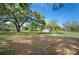 Large backyard with mature trees, green grass, and detached storage shed at 1310 Walt Williams Rd, Lakeland, FL 33809