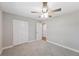 Bright bedroom features a ceiling fan, plush carpet, and spacious closet for optimal storage at 1310 Walt Williams Rd, Lakeland, FL 33809