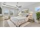 Bright bedroom featuring plush rug, ceiling fan, and elegant furnishings with natural light from two windows at 13119 Granger Ave, Orlando, FL 32827