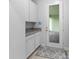 Functional mud room with granite countertops and cabinetry leading to outdoor patio at 13119 Granger Ave, Orlando, FL 32827