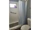 Bathroom featuring a shower with a curtain, grab bar, shelves and toilet at 1810 Blue Lake Dr, Lakeland, FL 33801