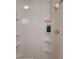 Shower area with built-in shelves, shower head, and a bottle of soap at 1810 Blue Lake Dr, Lakeland, FL 33801