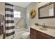 Well-maintained bathroom featuring a shower-tub combo, single sink vanity, and a decorative wreath for added charm at 2597 Highlands Vue Pkwy, Lakeland, FL 33812