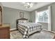 Charming bedroom featuring a large window, ceiling fan, and a comfortable bed, complemented by a stylish dresser at 2597 Highlands Vue Pkwy, Lakeland, FL 33812