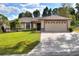 Charming single-story home features a well-maintained lawn, an attached two-car garage, and lush landscaping at 2597 Highlands Vue Pkwy, Lakeland, FL 33812