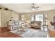 Inviting living room with leather sofas, tile flooring, a ceiling fan, and bright natural light from a bay window at 2597 Highlands Vue Pkwy, Lakeland, FL 33812