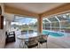 Screened-in porch overlooking a sparkling pool, furnished with comfortable chairs and a dining table for relaxation and enjoyment at 2597 Highlands Vue Pkwy, Lakeland, FL 33812