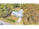 Aerial view showcasing the home's layout, metal roof, spacious yard, and surrounding greenery at 3035 Linda Dr, Lakeland, FL 33810