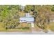 Aerial view of the home with metal roof surrounded by mature trees at 3035 Linda Dr, Lakeland, FL 33810