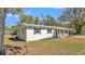 This single-story home has black shutters, a covered porch, and a well-manicured front yard at 3035 Linda Dr, Lakeland, FL 33810