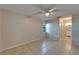 A bright bedroom with tile flooring, ceiling fan and window looking out at the landscape at 3823 Woodburn E Loop, Lakeland, FL 33813