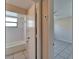 Hallway view to bathroom and bedroom with tiled floors and neutral colored walls at 3823 Woodburn E Loop, Lakeland, FL 33813