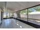 Large tiled screened porch with views of a spacious back yard with a white fence and mature trees at 3823 Woodburn E Loop, Lakeland, FL 33813