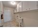 Utility room with sink, cabinets, tile floor, and access to outside at 3823 Woodburn E Loop, Lakeland, FL 33813