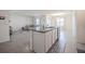 Kitchen island featuring granite countertops, white cabinetry, stainless steel appliances with an open concept living space at 3843 Resting Robin Ave, Bartow, FL 33830