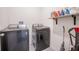 Laundry room featuring modern appliances, including a washer and dryer, with storage shelf at 3843 Resting Robin Ave, Bartow, FL 33830