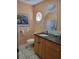 Bathroom with single vanity, granite countertop, oval mirror and framed artwork at 4025 Cheverly E Dr, Lakeland, FL 33813