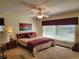 Cozy bedroom with neutral carpet, ceiling fan, and an art piece above the bed at 4025 Cheverly E Dr, Lakeland, FL 33813