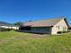 Back exterior with sunroom addition and well-manicured lawn at 4025 Cheverly E Dr, Lakeland, FL 33813