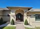 Elegant front entrance showcasing an arched entryway, brick pathway, and manicured bushes at 4025 Cheverly E Dr, Lakeland, FL 33813