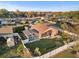 Aerial view of a home with lush landscaping, a two-car garage, a screened lanai, and fenced yard at 404 Emerald Cove Loop, Lakeland, FL 33813