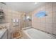 Tiled bathroom featuring a glass-enclosed shower, soaking tub, and a window with lots of natural light at 404 Emerald Cove Loop, Lakeland, FL 33813