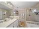 Tile bathroom featuring double sinks, a glass-enclosed shower, and a soaking tub at 404 Emerald Cove Loop, Lakeland, FL 33813