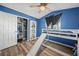 Nicely appointed bedroom featuring a bunk bed with a slide, wood-look floors, and blue accent wall at 404 Emerald Cove Loop, Lakeland, FL 33813