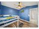 Bedroom with a blue accent wall featuring bunk beds and a ceiling fan at 404 Emerald Cove Loop, Lakeland, FL 33813