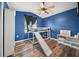 Vibrant blue bedroom featuring a bunk bed with slide, ceiling fan, and wood-look flooring at 404 Emerald Cove Loop, Lakeland, FL 33813