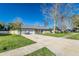 Inviting single-story home with a two-car garage, a long driveway, and a manicured lawn at 4059 The Fenway, Mulberry, FL 33860