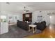 Inviting living room featuring a brick fireplace, wood floors, comfortable seating, and a ceiling fan at 4059 The Fenway, Mulberry, FL 33860