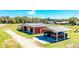 Aerial view showcases the property's barn, covered parking, and expansive grassy surroundings at 408 Old Bartow Lake Wales Rd, Bartow, FL 33830