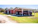 Exterior view of a barn with an attached carport and multiple vehicles parked underneath at 408 Old Bartow Lake Wales Rd, Bartow, FL 33830