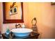 Stylish bathroom featuring a vessel sink, dark countertop, framed mirror, and decorative accents at 408 Old Bartow Lake Wales Rd, Bartow, FL 33830