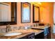 Well-lit en-suite bathroom with double sinks, granite countertops, framed mirrors, and stylish fixtures at 408 Old Bartow Lake Wales Rd, Bartow, FL 33830