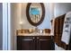 Bathroom vanity features a granite countertop with dark cabinets, bronze faucet and oval mirror at 408 Old Bartow Lake Wales Rd, Bartow, FL 33830