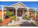 Inviting front porch featuring a pergola, stone accents, lush plants, and a welcoming walkway to the front door at 408 Old Bartow Lake Wales Rd, Bartow, FL 33830