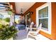 Cozy front porch with white Adirondack chairs, floral arrangements, and a hanging pendant light creating a charming outdoor space at 408 Old Bartow Lake Wales Rd, Bartow, FL 33830