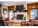 Cozy living room showcasing a stone fireplace, wood paneling, plush seating, and natural light at 408 Old Bartow Lake Wales Rd, Bartow, FL 33830