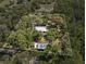 Aerial view of a property with a white boundary showing the house and garage set in a densely wooded area at 4410 Rushing Rd, Lakeland, FL 33810