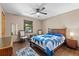 Cozy bedroom with wood floors, ceiling fan, and a comfy bed with a blue and white patterned quilt at 4410 Rushing Rd, Lakeland, FL 33810