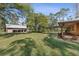 Spacious backyard featuring a large garage and a covered carport near the wooden home at 4410 Rushing Rd, Lakeland, FL 33810