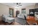 Comfortable living room with gray sofa, chair, wood floors, natural lighting, and functional workspace at 4410 Rushing Rd, Lakeland, FL 33810