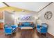 Bright seating area featuring a stylish blue sofa and chairs, a colorful painting, and hardwood floors at 4410 Rushing Rd, Lakeland, FL 33810