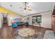 Cozy living room with wood floors, a ceiling fan, and stylish blue seating around a round rug at 4410 Rushing Rd, Lakeland, FL 33810