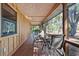 Covered porch featuring wood flooring and a dining table, perfect for outdoor dining and relaxation at 4410 Rushing Rd, Lakeland, FL 33810