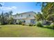 Expansive backyard with lush green grass, mature trees, and a bright blue sky above at 4908 S Bedford Ln, Lakeland, FL 33813