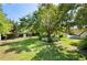 Expansive backyard with lush green grass and mature trees, and a bright blue sky above at 4908 S Bedford Ln, Lakeland, FL 33813